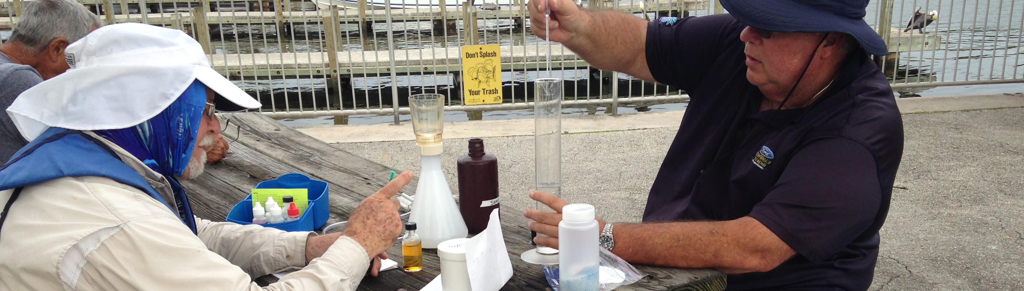 photo of two water watch volunteers filtering a a water sample
